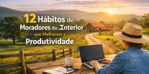 Pessoa com chapéu de palha usa laptop ao ar livre em mesa de madeira, com nascer do sol ao fundo.